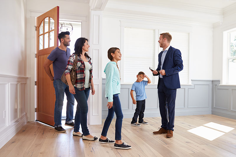 Realtor Showing a house for sale to a family after home inspection services are scheduled 